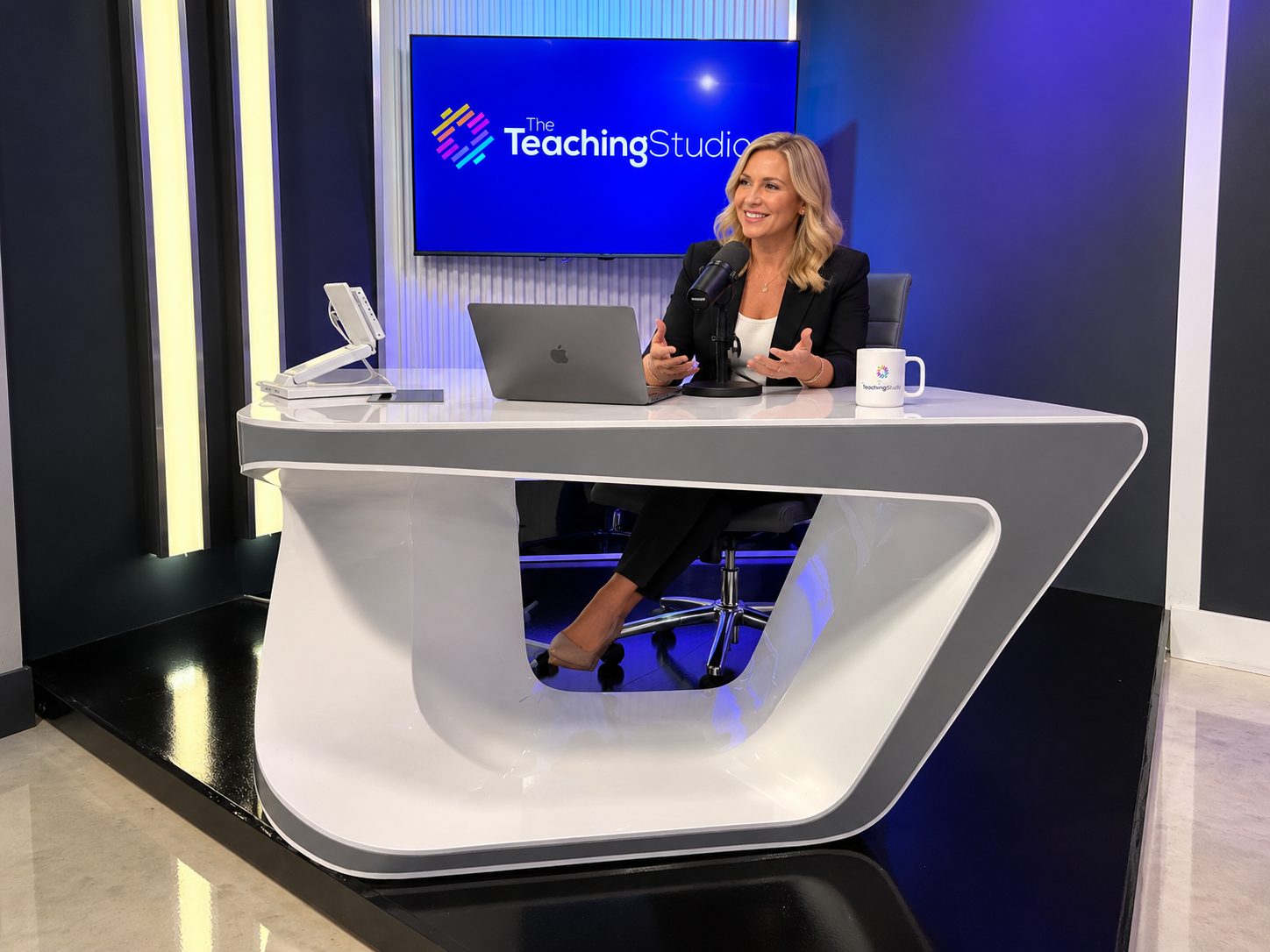The Podcast Desk with a laptop, microphone and branded screen
